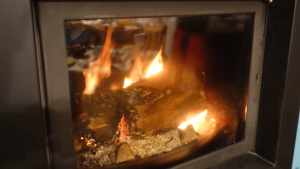 Poele à bois bien entretenu avec une vitre propre et des cendres vidées régulièrement.